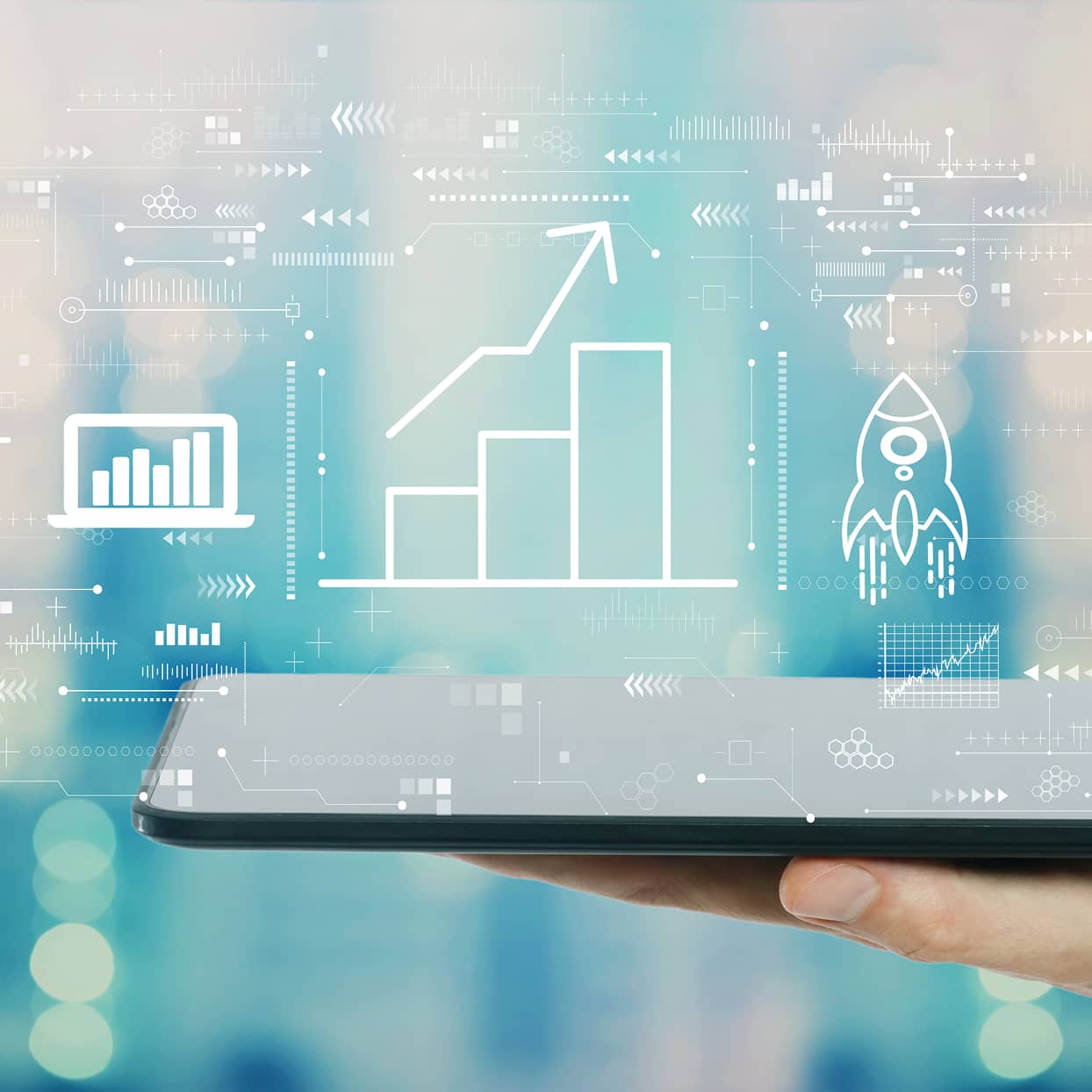 タブレットの上に成長グラフやロケットのアイコンが浮かぶ未来的なビジュアル